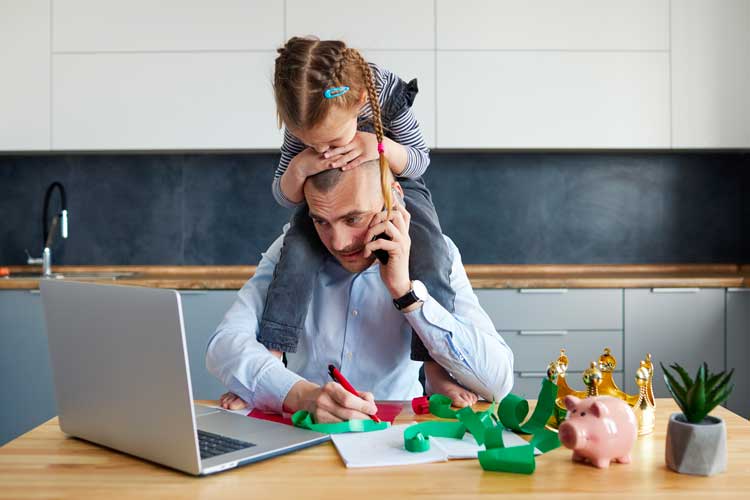 Dad working from home with his daughter crawling on him