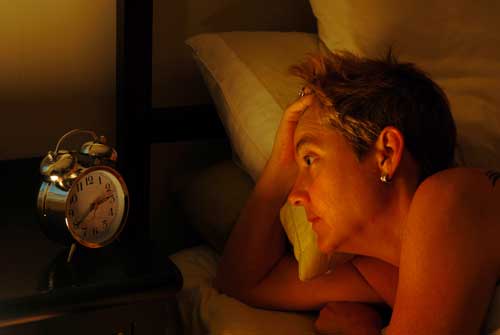 woman staring at the clock at 2 in the morning